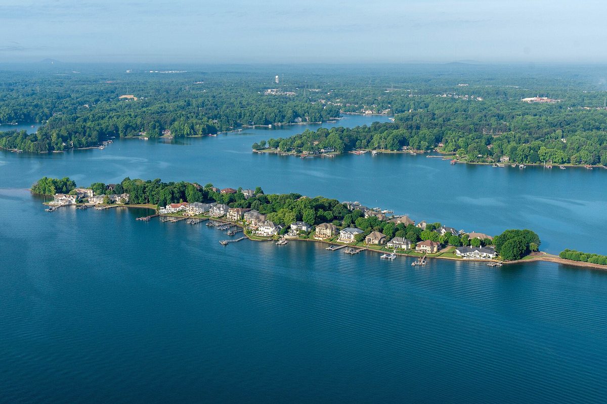 A wooded peninsula of lakefront homes and docks juts into Lake Norman north of Charlotte, hazy tree-lined shores beyond