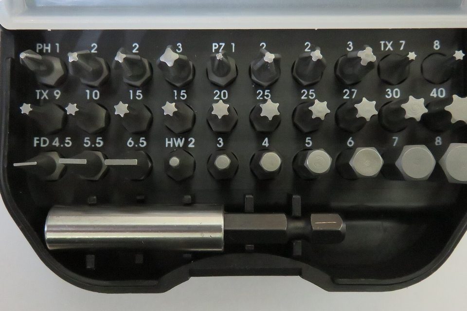 Open plastic case of screwdriver bits labelled PH, PZ, TX and hex sizes, with a magnetic holder