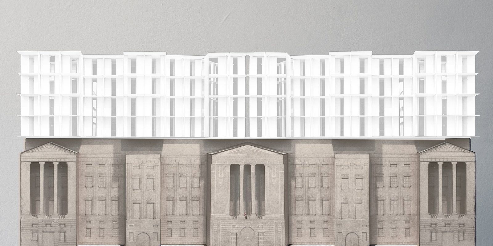 Architectural study model of a white multi storey addition sitting above a grey classical stone facade