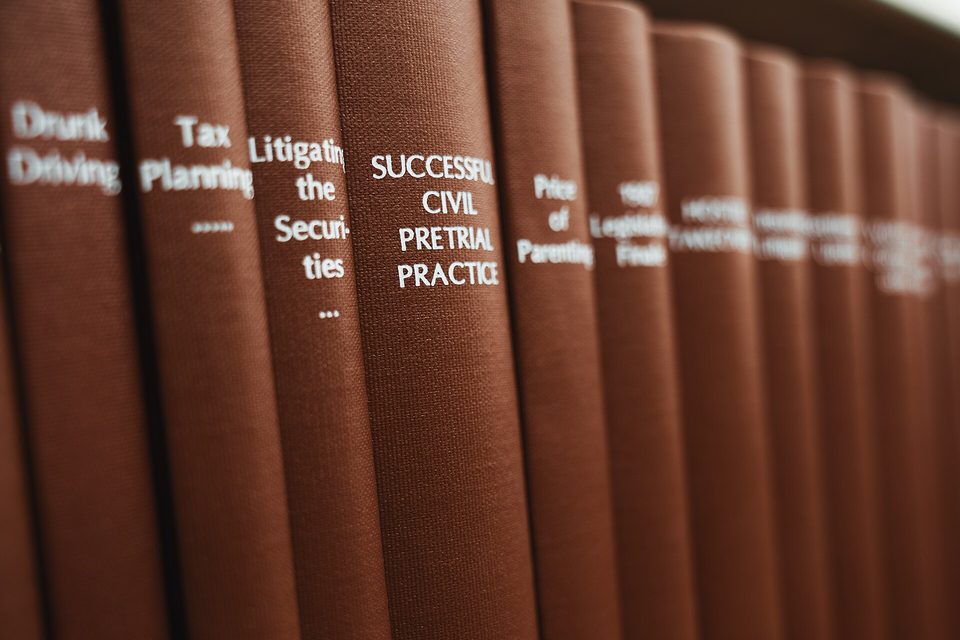 A close row of brown cloth law books with titles such as Tax Planning and Successful Civil Pretrial Practice